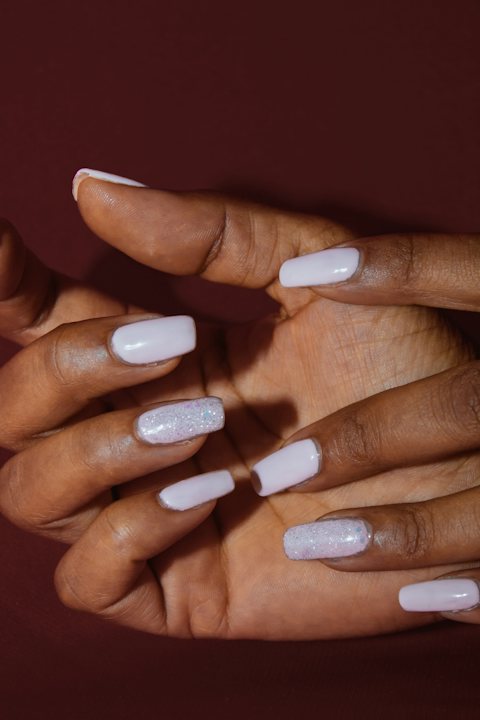 Milky white nails against a burgundy background