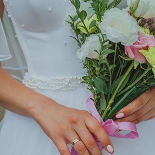Bride holding a bouquet with a soft bridal manicure